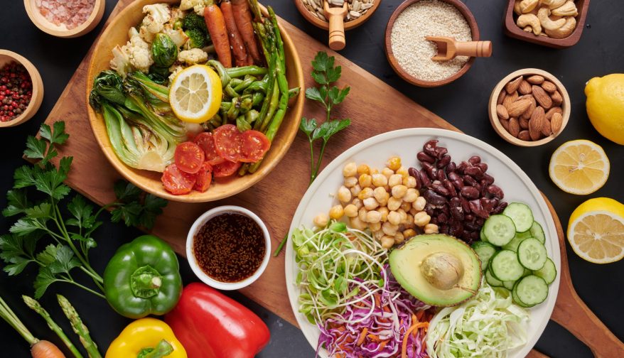 Vegan protein source. Buddha bowl dish, avocado, pepper, tomato, cucumber, red cabbage, chickpea, fresh lettuce salad and walnuts, nuts, beans, . Healthy vegetarian eating, super food. Top view.